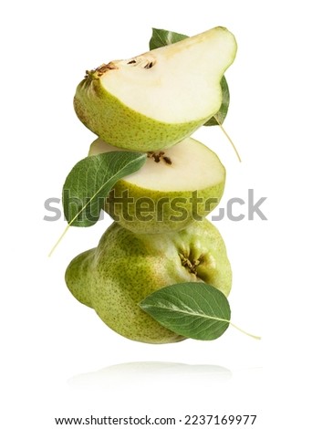 Fresh ripe green pear with leaves falling in the air, isolated on white background. Food levitation or zero gravity concept. High resolution image