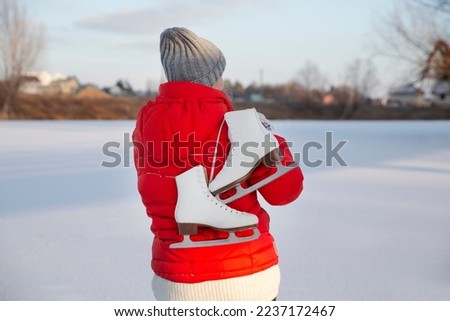  senior woman with ice skates on a frozen lake  in winter nature. Enjoying the little things. Winter Vibes. christmas holiday
