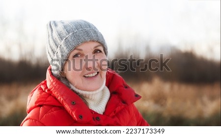 portrait of a cheerful senior woman   in winter nature. Enjoying the little things. Winter Vibes. christmas holiday. copy space