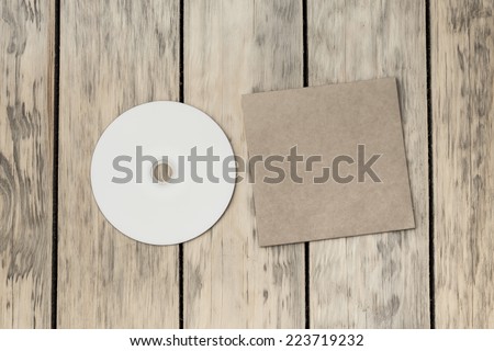 Blank compact disk and cover on wood background
