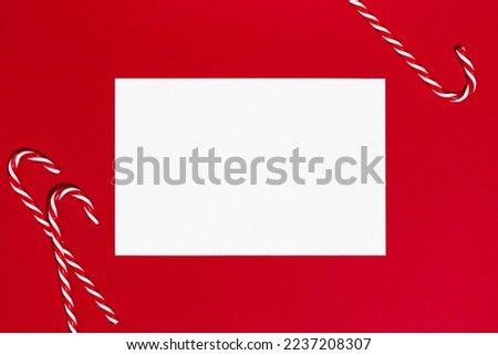 Christmas letter mockup. Blank white empty page on red background with a candy cane. Postcard, greetings and thank you card template.