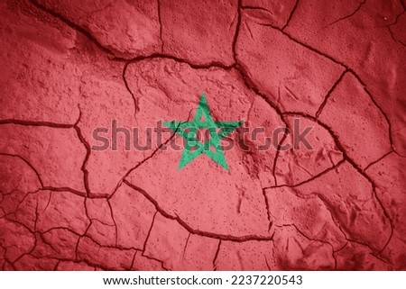 Flag of Marocco. Maroccan symbol. Flag on the background of dry cracked earth. Maroccan flag with drought concept