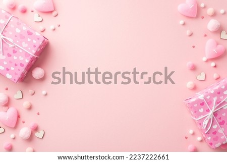 St Valentine's Day concept. Top view photo of present boxes heart shaped candles sprinkles and fluffy pompons on isolated pastel pink background with empty space