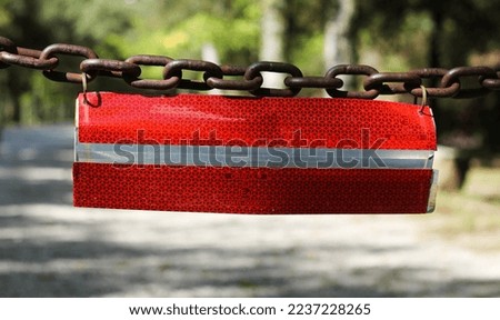 vintage metal chain with a prohibition road sign on the background of a park road
