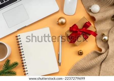 Christmas office table with coffee cup, laptop, Xmas decorations on yellow background. Flat lay, top view. New Year workspace.