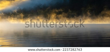 Foggy lake with sunlight. Nature abstract backgrounds wallpaper of the lake is illuminated by the sun