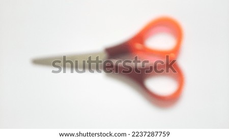 Blurred or unfocused or defocused single or one red orange brown scissor on isolated white background