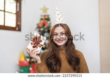 Portrait of smiling asian woman with Christmas gift at home