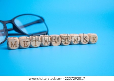 wooden cube with the word metaverse tilted to the left and a blurred blue background.