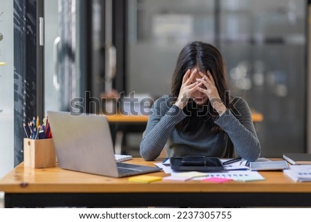 Portrait of tired young business Asian woman work with documents tax laptop computer in office. Sad, unhappy, Worried, Depression, or employee life stress concept	 Royalty-Free Stock Photo #2237305755