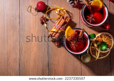 Christmas winter mulled wine drink. Classic style mulled red wine cocktail with orange slice, cinnamon, spices, on festive Christmas, New Year Noel decorated wooden background copy space