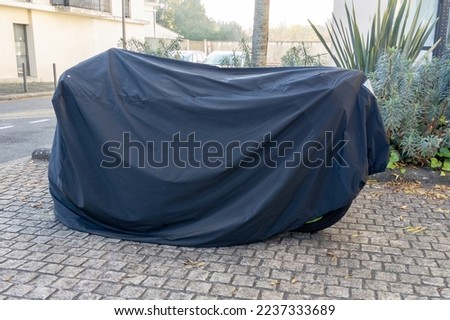 motorcycle grey protect by bike protective plastic cover in city street motorbike with tarpaulin gray jacket Royalty-Free Stock Photo #2237333689