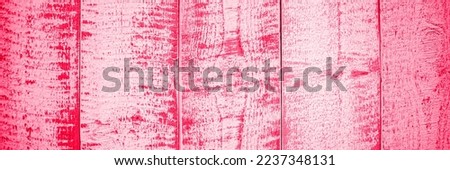 Banner. Light red wood plank wall or table texture background. Colored Viva Magenta trendy color of the year 2023