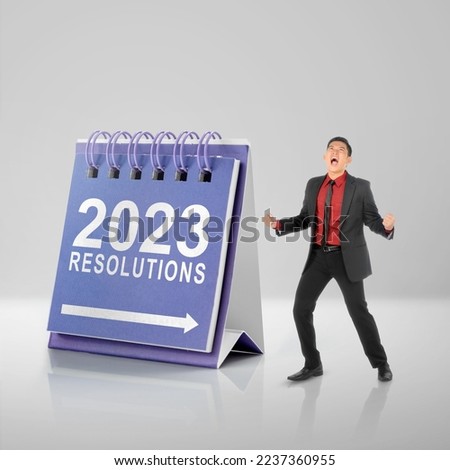 Asian businessman with excited expression with a calendar for 2023 resolution. Resolution of 2023. Happy New Year 2023