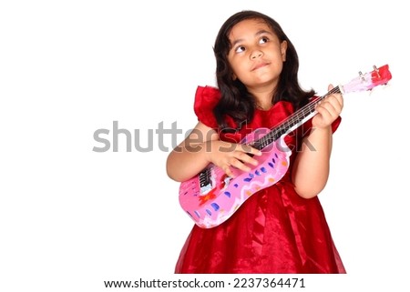 asian little girl on white background isolated (6 year old) was playing the ukulele