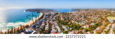 Scenic famous Manly beach on Sydney Northern beaches in wide aerial panorama of harbour and distant CBD. Royalty-Free Stock Photo #2237372221