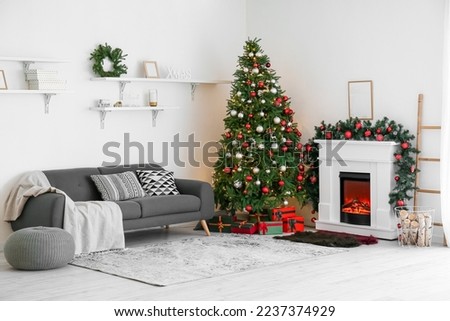 Interior of living room with fireplace, Christmas tree and sofa
