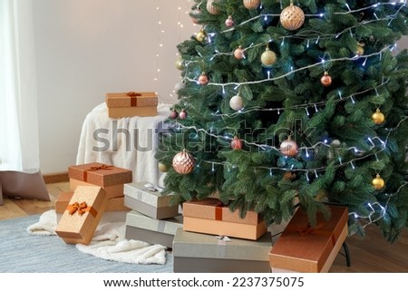Beautiful Christmas tree with presents and pouf in living room