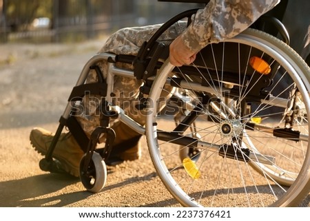 Young soldier in wheelchair outdoors, closeup Royalty-Free Stock Photo #2237376421