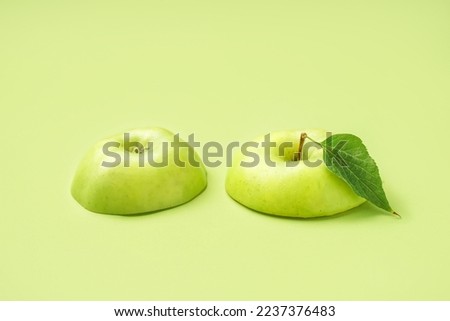 Pieces of juicy green apple on color background