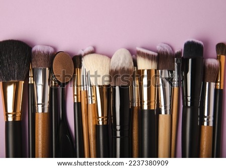 Cosmetic brush for make-up on a lilac background. Cosmetic product for make-up. Creative and beauty fashion concept. Fashion. Collection of cosmetic makeup brushes, top view, banner.Place for text. 
