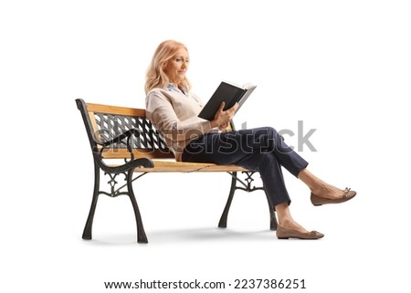 Mature woman sitting on a bench and reading a book isolated on white background Royalty-Free Stock Photo #2237386251