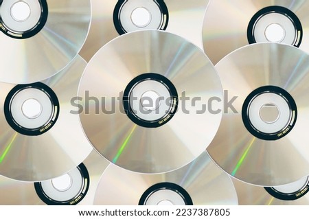 Many old CDs represent technology from the 90s. Stacks of CDs, old songs and old movies. which had been used before and placed on a white table. closeup, selective focus
