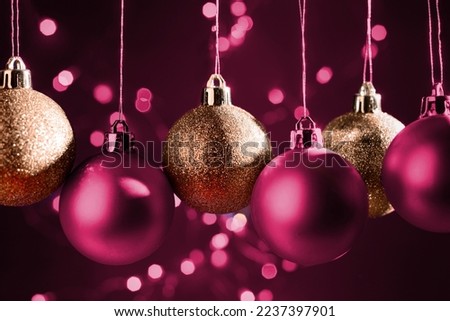 Happy Holidays 2023. New Year or Christmas Eve background with Decoration Balls on a Viva Magenta Color of the Year.