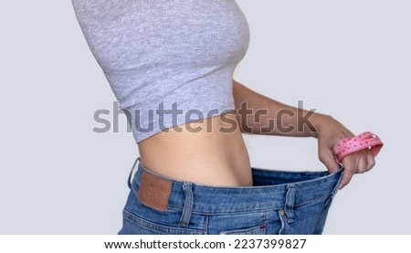 weight loss slim fit after childbirth recovery.woman legs in short pants with vacuum cup anti cellulite procedures wide banner.girl showing large plus size jeans pants hold measure tape around fist Royalty-Free Stock Photo #2237399827