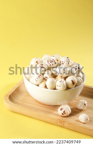 Makhana, also called as Lotus Seeds or Fox Nuts are popular dry snacks from India, served in a bowl. selective focus Royalty-Free Stock Photo #2237409749