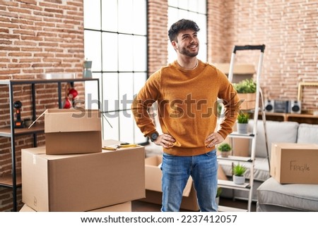 Young hispanic man smiling confident standing at new home Royalty-Free Stock Photo #2237412057