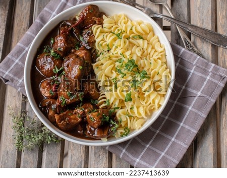Poultry goulash with pasta on a plate. Cooked with low fat turkey breast and served ready to eat on wooden background from above Royalty-Free Stock Photo #2237413639