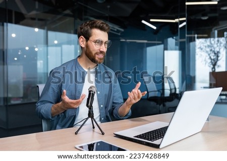 Business coach inside office recording audio podcast, businessman working at laptop using professional microphone and laptop for online radio, and training Remote.