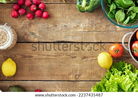 Frame of various vegetables and cereals for preparing dietary food on wooden background top view. Healthy and diet food concept