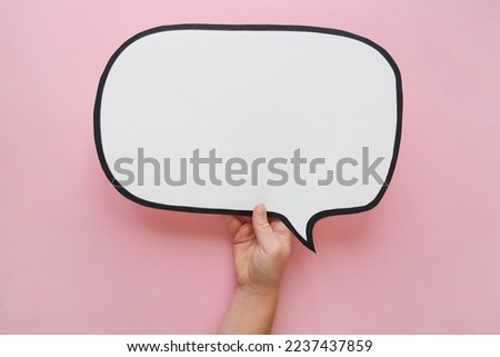 Speech bubble in hand on a pink background. Comic cloud with a place for text