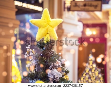 A shaggy yellow star on the Christmas tree . The top of the Christmas tree . Decoration .