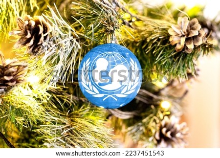New Year's glass ball with the flag of United Nations Children's Fund against a colorful Christmas background