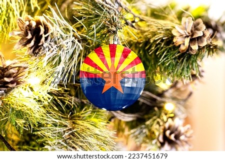 New Year's glass ball with the flag of State of Arizona against a colorful Christmas background