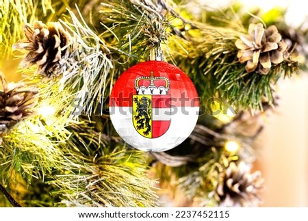 New Year's glass ball with the flag of Salzburg against a colorful Christmas background