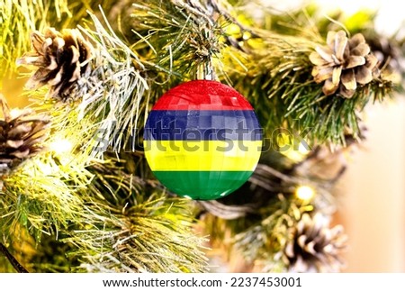 New Year's glass ball with the flag of Mauritius against a colorful Christmas background