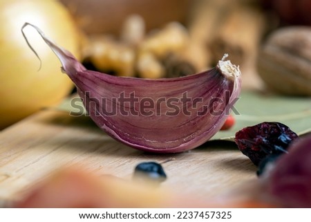 Garlic on the kitchen table during cooking, using red garlic and other spices for cooking meat and other dishes