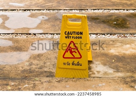 Sign showing warning of caution wet floor in rainy season.