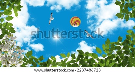 Stretch ceiling decoration image.Green tree leaves, flying seagulls and hot air balloon. Bottom up view of sky.