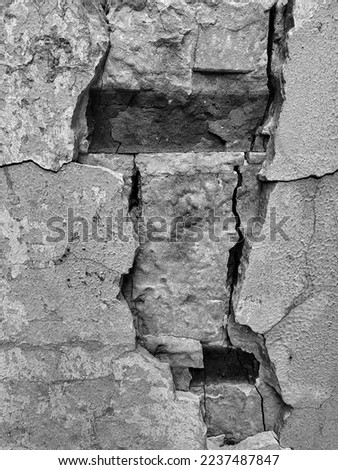 An old broken concrete wall. A crack on a brick wall. Grunge art for the interior.