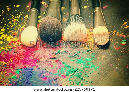 Makeup brushes on background with colorful powder. Make-up background  Royalty-Free Stock Photo #223750171