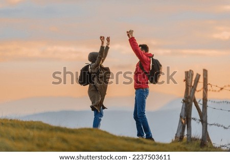 A happy Muslim couple celebrating successfully completing the walking route during the hiking on the mountain. 