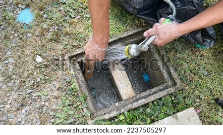 Cleaning inside the grease trap by scrub with a steel wire brush, some soap and water. Royalty-Free Stock Photo #2237505297