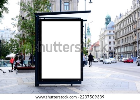 bus shelter with blank ad panel. billboard display. empty white lightbox sign at bus stop. billboard mockup. glass structure. city transit station. urban street. park setting. outdoor advertising. Royalty-Free Stock Photo #2237509339