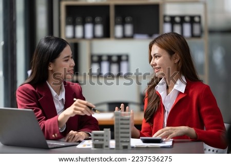 Asian businesswoman making a deal to buy a house or condo inside the office, home insurance concept