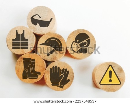 Icons of safety at workplace on wooden blocks and attention symbol isolated white background.Concept of workplace safety Or Safety at work.